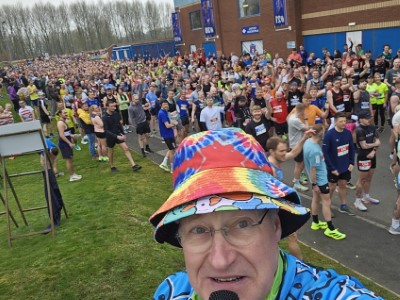 Brian Porter commentating in front of a large field of runners at Run Carlisle
